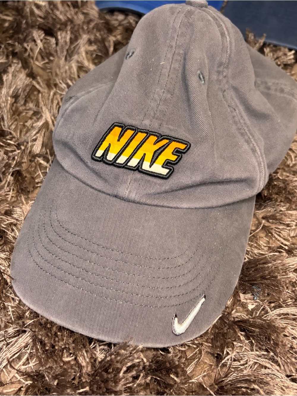Vintage-style gray Nike dad hat featuring a bold yellow & black block logo patch